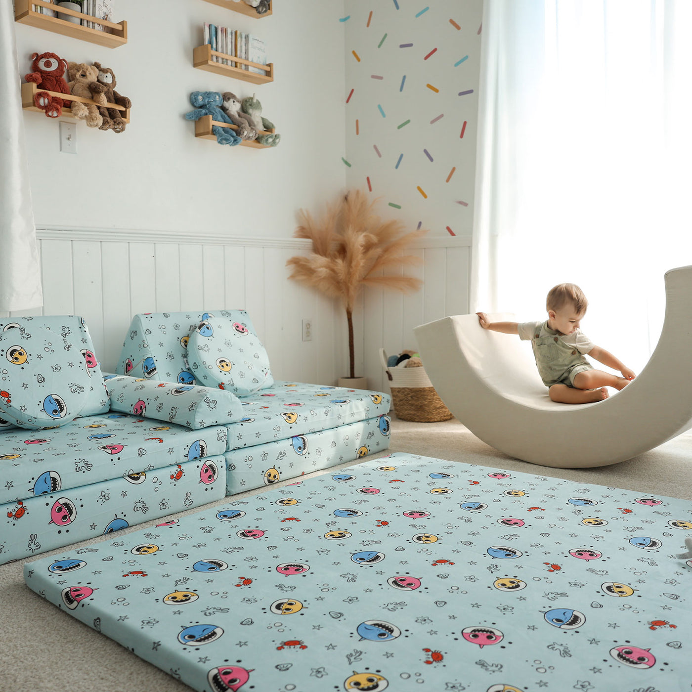 Little sitting on the Baby Shark™ x Roo & You™ Play Mat next to the Joey Play Couch.