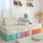 Toddler sitting on Miffy™ x Roo & You™ Joey Play Couch covered in bunny print.