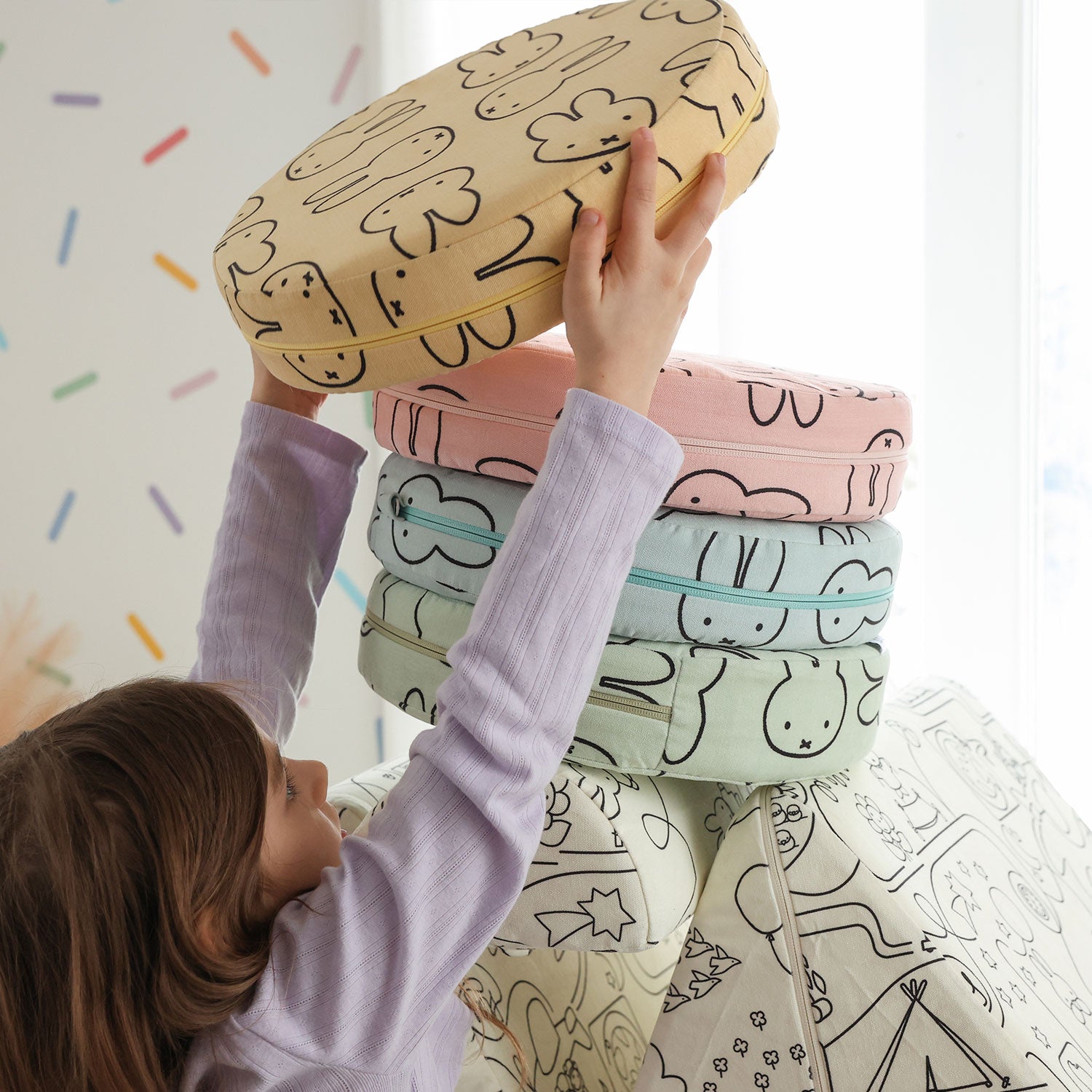 Child stacking colorful Miffy Stepping Stones with bunny print